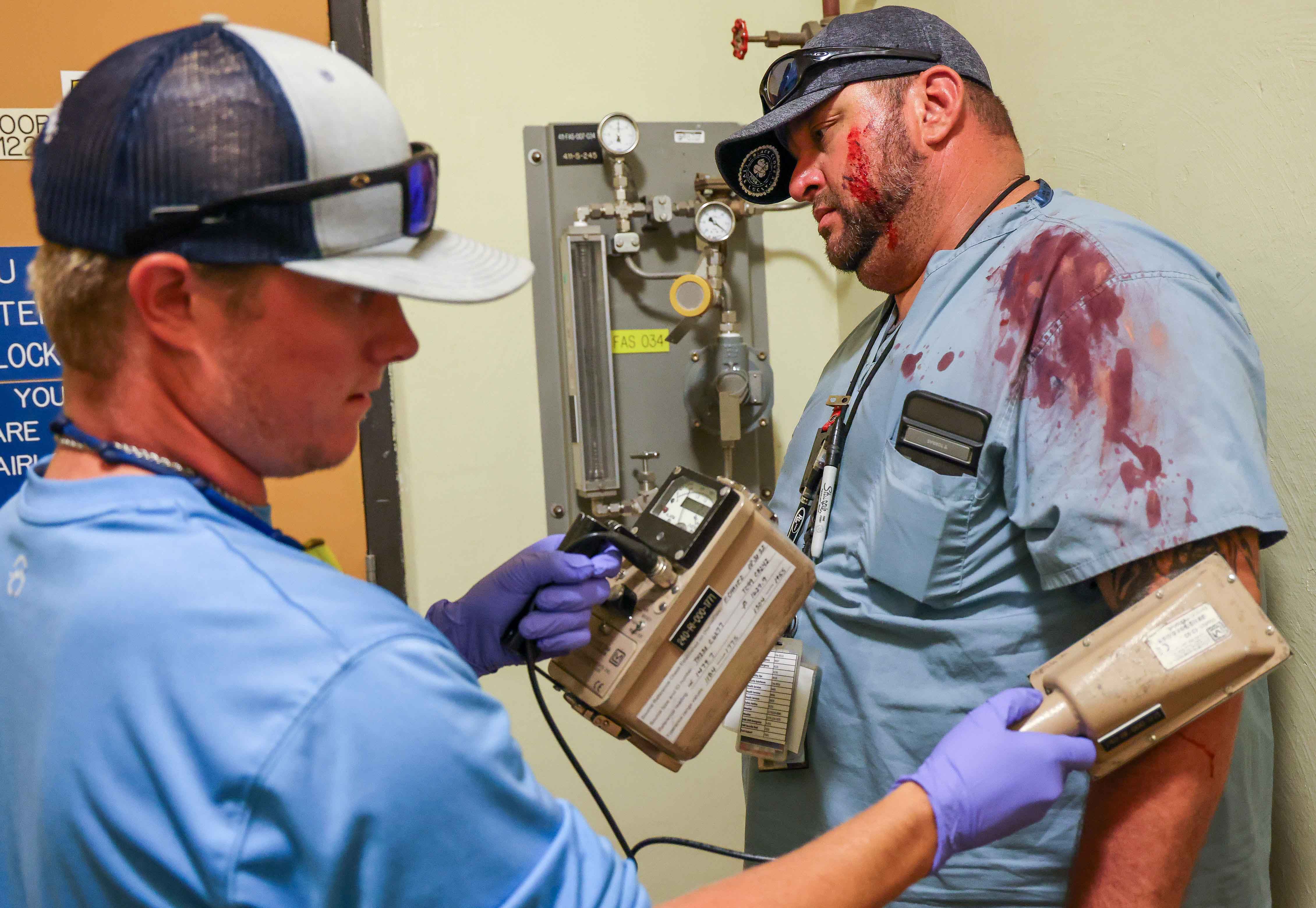 A radcon tech checks on a bloodied victim during the exercise